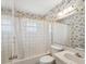 Clean bathroom with floral wallpaper and a shower/tub combo at 7037 Versailles N # 15, Pinellas Park, FL 33781
