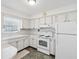 White kitchen with stove, cabinets, and a peninsula counter at 7037 Versailles N # 15, Pinellas Park, FL 33781