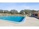 Community pool with lounge chairs and surrounding landscaping at 7037 Versailles N # 15, Pinellas Park, FL 33781