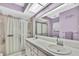 Bathroom with double vanity, shower, and large mirror at 7267 Prince George Ct, Spring Hill, FL 34606