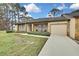 Tan house with stone facade, 2-car garage, and landscaped yard at 7267 Prince George Ct, Spring Hill, FL 34606