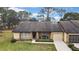 Tan single story home with a two car garage and green lawn at 7267 Prince George Ct, Spring Hill, FL 34606