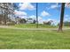 Scenic view of a lush green golf course with mature trees under a partly cloudy sky at 7267 Prince George Ct, Spring Hill, FL 34606
