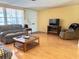 Living room featuring hardwood floors, a sofa, and a large TV at 7421 Ashwood Dr, Port Richey, FL 34668