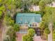 Aerial view of a two story house, green roof, and brick driveway at 8711 Betty St, Port Richey, FL 34668