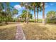 Brick pathway leads to a thatched gazebo in a tropical backyard setting at 8711 Betty St, Port Richey, FL 34668
