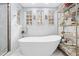 Bathroom with freestanding tub, walk-in shower, and marble tile at 8711 Betty St, Port Richey, FL 34668