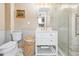 Bathroom with white vanity, marble shower, and toilet at 8711 Betty St, Port Richey, FL 34668