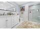 Bathroom with double vanity, walk-in shower, and marble flooring at 8711 Betty St, Port Richey, FL 34668