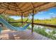 Relaxing hammock on a gazebo deck overlooking tranquil water at 8711 Betty St, Port Richey, FL 34668