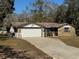 Ranch-style home with stone accents, attached garage, and mature landscaping at 9741 Star Trl, New Port Richey, FL 34654
