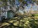 Charming green storage shed with x-design doors in backyard at 9741 Star Trl, New Port Richey, FL 34654