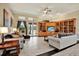 Bright living room with hardwood floors, built in shelving and a view to the backyard at 10030 Orchard Way, Spring Hill, FL 34608