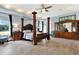 Luxurious main bedroom with a large four poster bed and walk-in closet at 10030 Orchard Way, Spring Hill, FL 34608