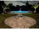 Night view of a refreshing pool with a fire pit and patio area at 10030 Orchard Way, Spring Hill, FL 34608