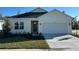 One-story home with white exterior, two-car garage, and landscaped front yard at 10123 Zennia Ln, Parrish, FL 34219