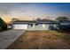 Single-story home with gray siding, attached garage, and front yard at 10147 Spring Hill Dr, Spring Hill, FL 34608