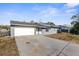 Charming single-story home showcasing a spacious driveway, two car garage and freshly painted exterior at 10147 Spring Hill Dr, Spring Hill, FL 34608
