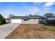 Gray house with white garage door and landscaping at 10147 Spring Hill Dr, Spring Hill, FL 34608