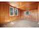 Charming bedroom featuring wood walls, wood floors and two windows at 106 Banana St, Tarpon Springs, FL 34689