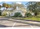 White house with green accents, mature trees, and a sidewalk at 106 Banana St, Tarpon Springs, FL 34689