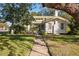 Charming white house with green roof, spacious yard, and walkway at 106 Banana St, Tarpon Springs, FL 34689