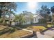 Two-story white house with green roof, lush landscaping, and a long driveway at 106 Banana St, Tarpon Springs, FL 34689
