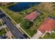 Aerial view of a home with red tiled roof, scenic lake view, and lush landscaping at 1082 Dartford Dr, Tarpon Springs, FL 34688