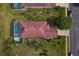 Bird's eye view of a home with screened pool, a red tile roof, and manicured yard at 1082 Dartford Dr, Tarpon Springs, FL 34688