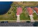 Aerial view of a home featuring a red tile roof, a pond view, and mature landscaping at 1082 Dartford Dr, Tarpon Springs, FL 34688