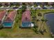 Overhead shot of a home showcasing a screened pool area, red tile roof, and backyard pond at 1082 Dartford Dr, Tarpon Springs, FL 34688