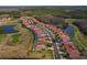 Expansive aerial view of a residential community featuring lush green lawns, a golf course, and scenic water features at 1082 Dartford Dr, Tarpon Springs, FL 34688