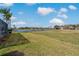 Lush green backyard with lake view and swaying palm trees at 1082 Dartford Dr, Tarpon Springs, FL 34688