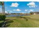 Scenic backyard view with a serene lake and lush green lawn at 1082 Dartford Dr, Tarpon Springs, FL 34688