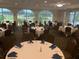 Spacious banquet room with views of the greens and round tables set with blue napkins at 1082 Dartford Dr, Tarpon Springs, FL 34688