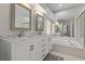 Bathroom featuring a double sink vanity with marble countertop and a separate tub at 1082 Dartford Dr, Tarpon Springs, FL 34688