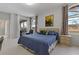 Bright bedroom with a blue comforter, light wood furniture, and an adjacent outdoor seating area at 1082 Dartford Dr, Tarpon Springs, FL 34688