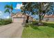 Charming single-story home featuring a red tile roof, manicured lawn, and mature landscaping at 1082 Dartford Dr, Tarpon Springs, FL 34688
