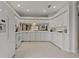 Well-lit kitchen featuring white cabinetry, modern appliances, and neutral-toned tile flooring at 1082 Dartford Dr, Tarpon Springs, FL 34688