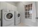 Laundry room equipped with a washer, dryer, and white cabinets for storage at 1082 Dartford Dr, Tarpon Springs, FL 34688