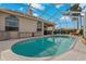 A screened-in pool reflects the sky and back of the house at 1082 Dartford Dr, Tarpon Springs, FL 34688