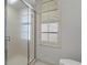 Close up of a glass enclosed shower with chrome hardware and a shuttered window at 1082 Dartford Dr, Tarpon Springs, FL 34688