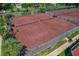Overhead shot of several well-kept tennis courts with green fencing and landscaping at 1082 Dartford Dr, Tarpon Springs, FL 34688