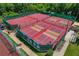 Aerial view of well-maintained tennis and pickleball courts surrounded by lush greenery at 1082 Dartford Dr, Tarpon Springs, FL 34688