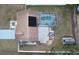 Aerial view of a home featuring a screened pool, solar panel, and a spacious, fenced backyard at 11731 Linden Dr, Spring Hill, FL 34608