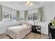 Bright bedroom featuring wood floors, two windows and a ceiling fan at 11731 Linden Dr, Spring Hill, FL 34608