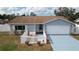 Inviting home exterior featuring a cozy porch swing, well-maintained lawn, and a bright blue driveway at 11731 Linden Dr, Spring Hill, FL 34608