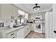 Well-lit kitchen featuring white appliances, light wood flooring, neutral countertops, and stainless steel sink at 11731 Linden Dr, Spring Hill, FL 34608