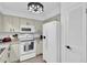 Modern kitchen featuring white appliances, neutral countertops, and unique light fixture at 11731 Linden Dr, Spring Hill, FL 34608