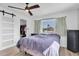 Bright main bedroom featuring a ceiling fan, closet, a view to the outside, and light-colored flooring at 11731 Linden Dr, Spring Hill, FL 34608